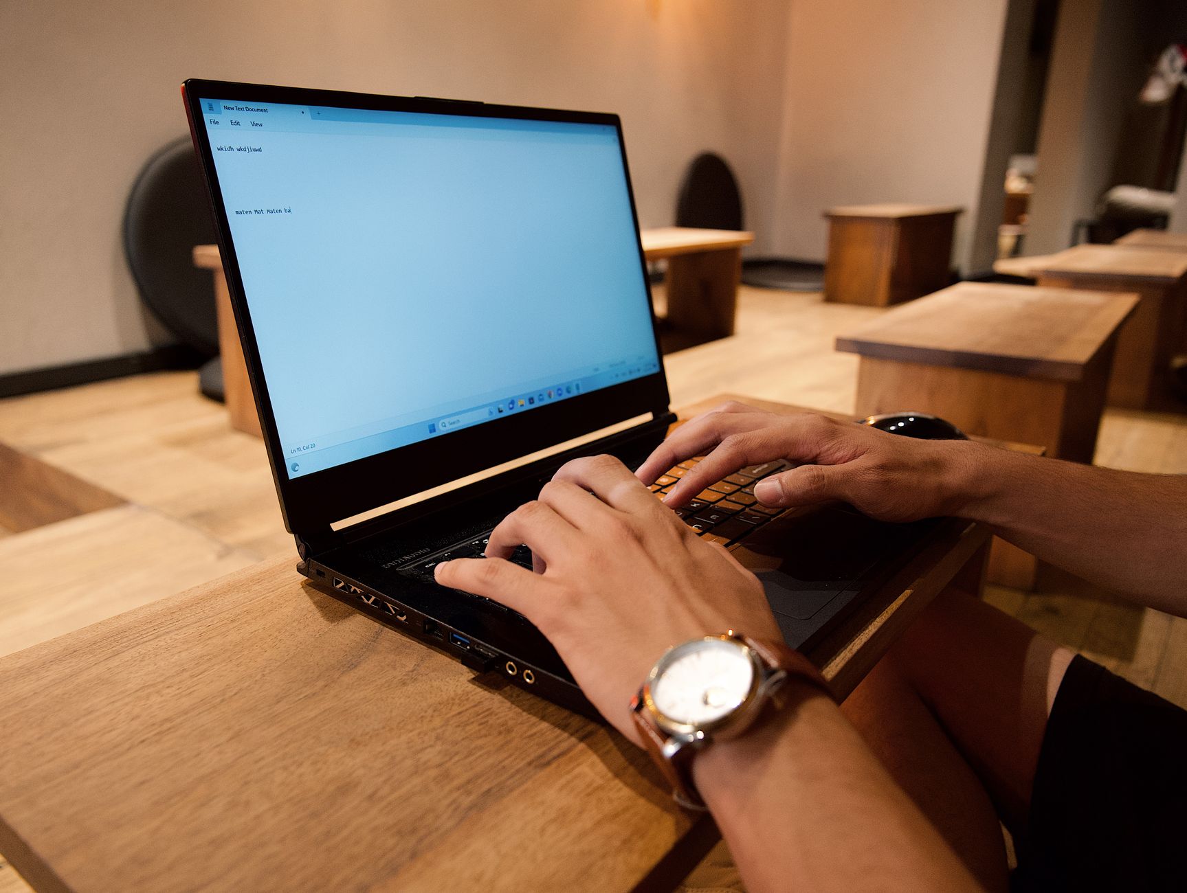 A person editing their resume on a laptop with split-screen showing a job description and a text editor
