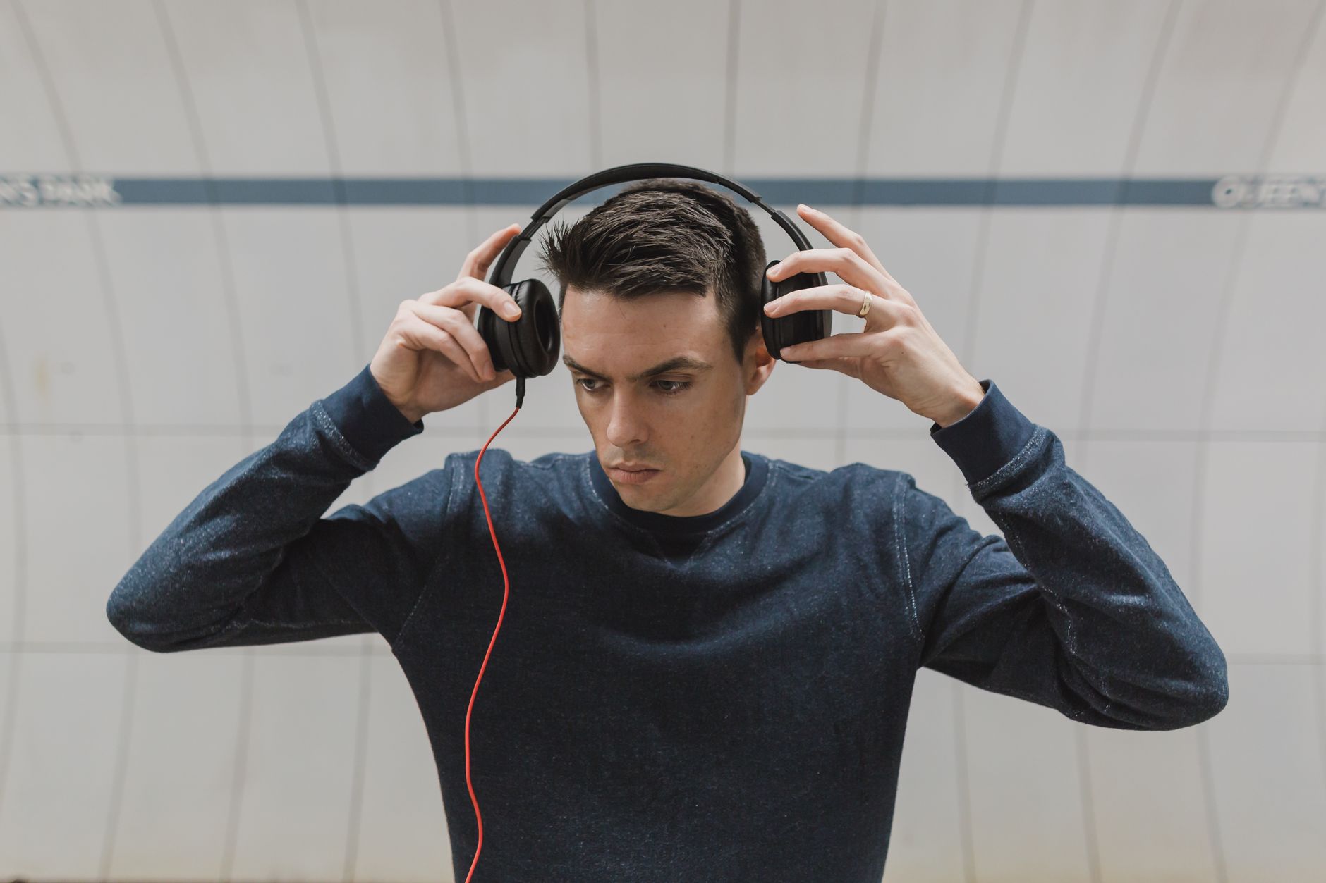 Person wearing premium over-ear noise-canceling headphones while waiting at an airport terminal