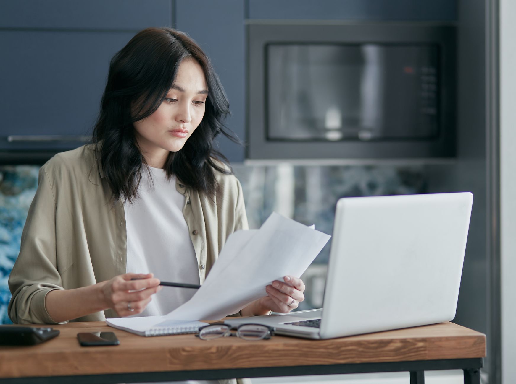 Person sitting at a clean desk reading a long document on a modern laptop screen