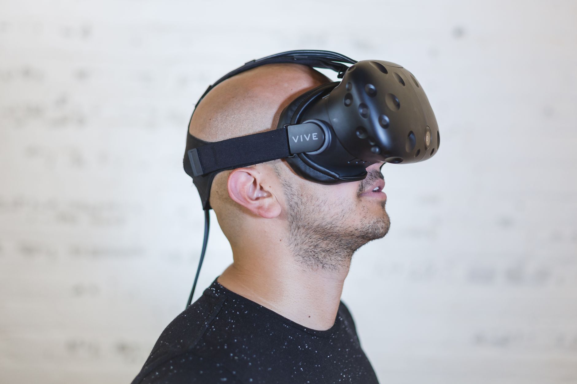 A person wearing a virtual reality headset holding motion controllers while playing a game.