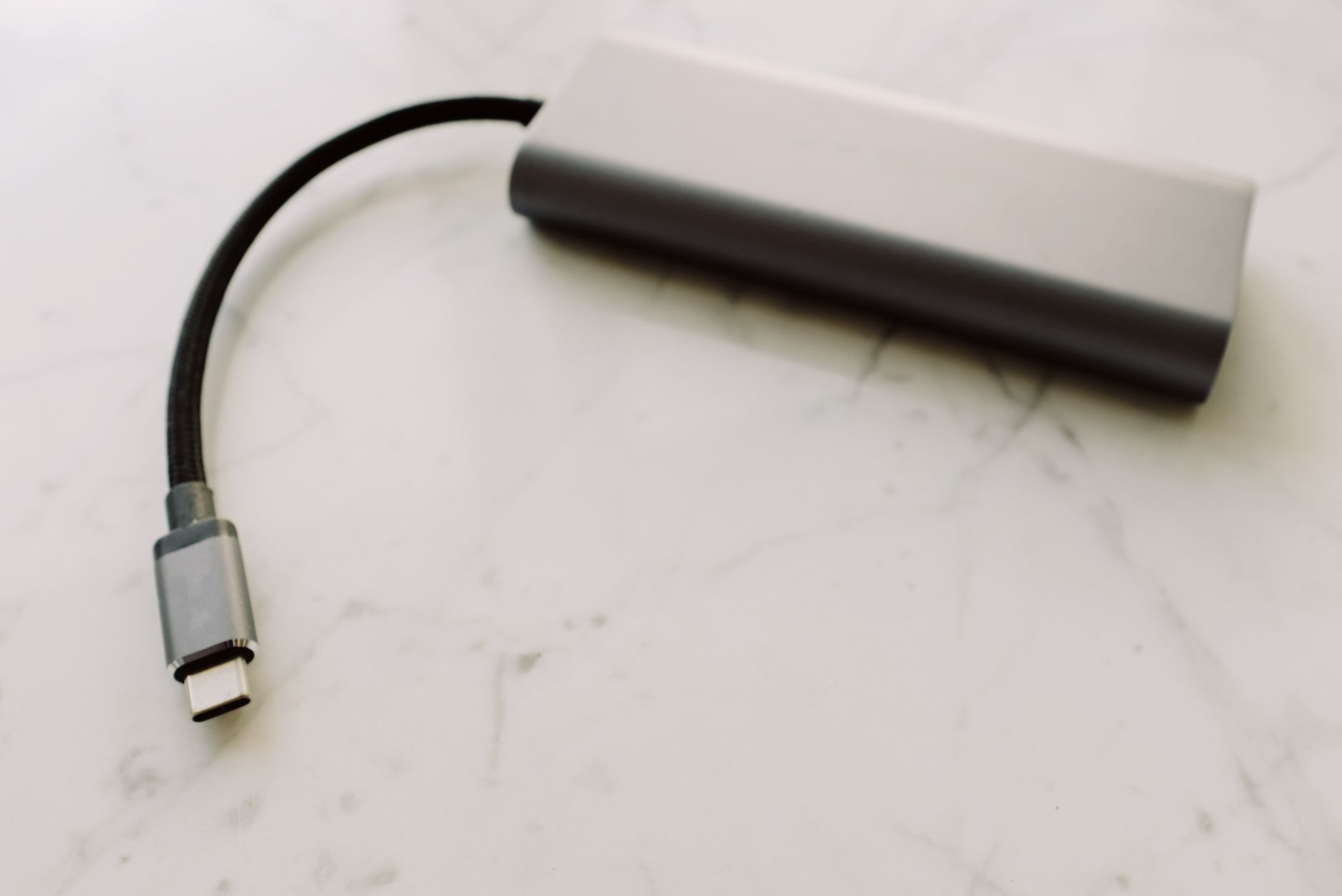 Modern laptop plugged into a sleek high-wattage USB-C fast charger on a desk